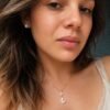 Woman wearing a 925 sterling silver butterfly necklace with mother of pearl and matching stud earrings