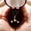 Woman holding a 925 sterling silver butterfly necklace and earrings set in a burgundy velvet gift box